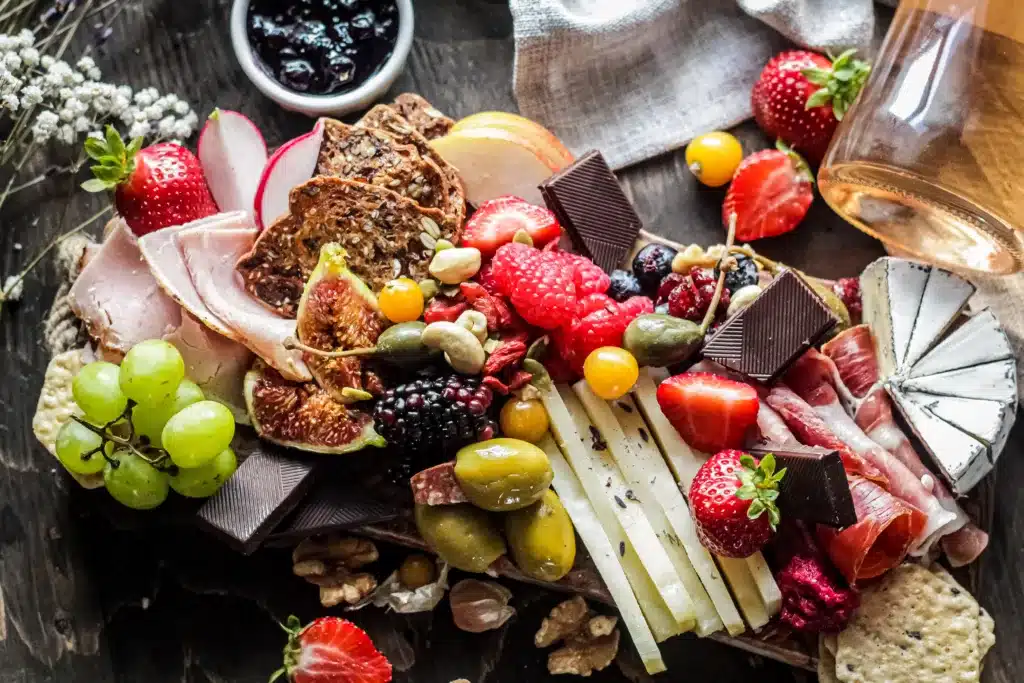 Charcuterie board with colorful cheeses, meats, and fruits