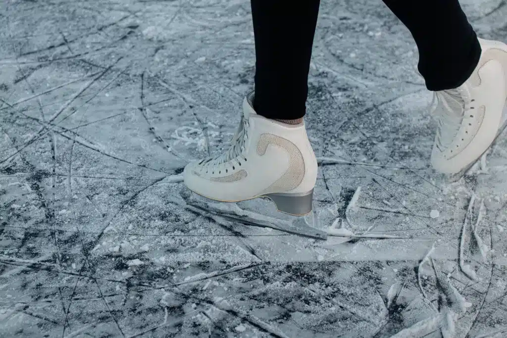 Person wearing white ice skates on the ice