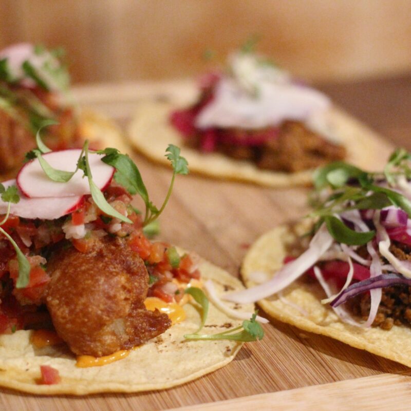 An image of four tacos on tray