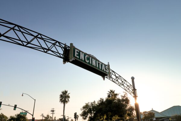 Encinitas street sign hanging from the side of a metal structure