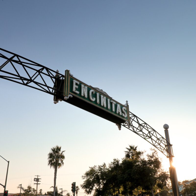 Encinitas street sign hanging from the side of a metal structure