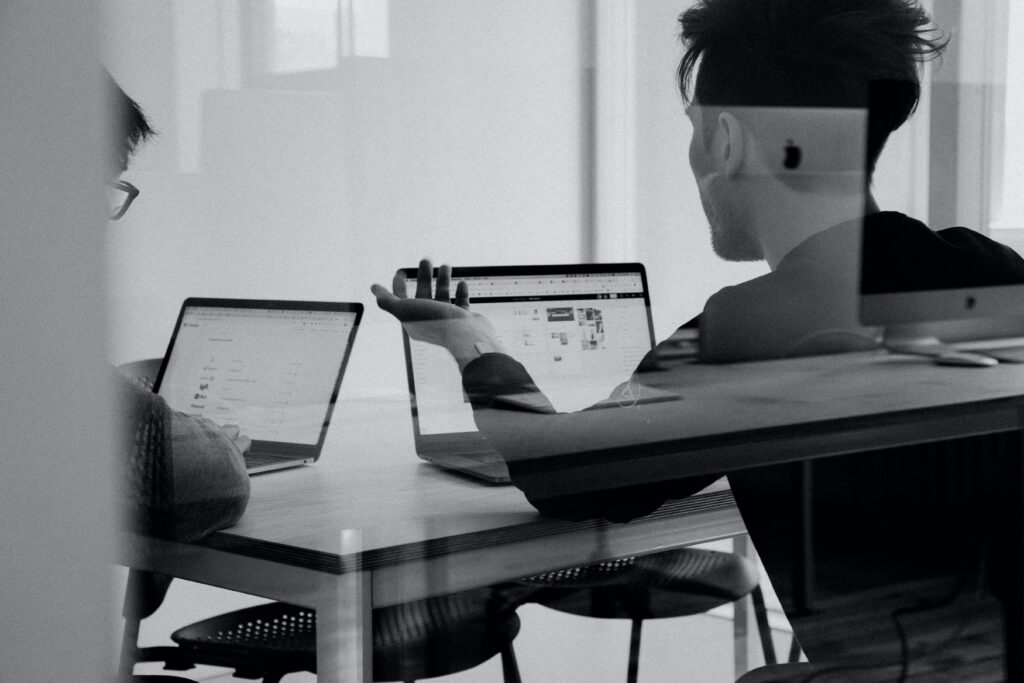 Two people in a meeting with their laptops open