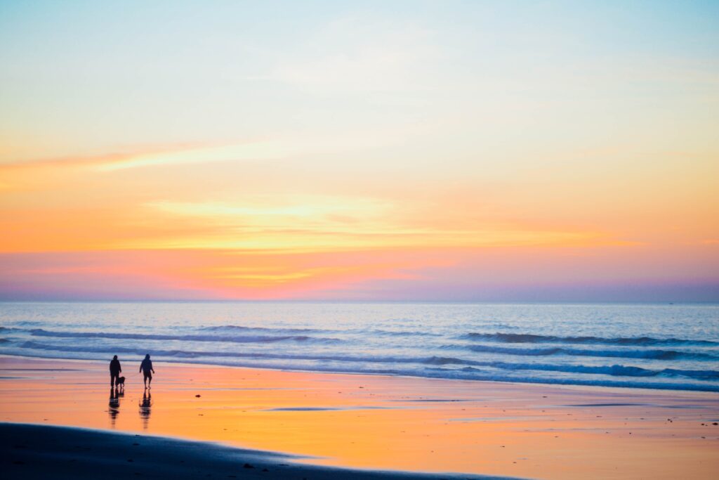 A couple walking the seashore during sunset