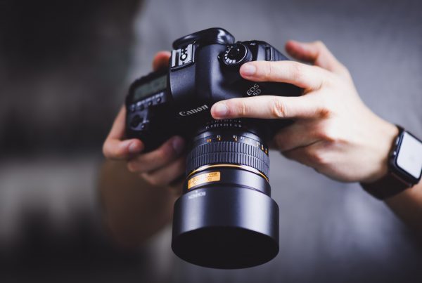 Image of a person holding Canon DSLR camera